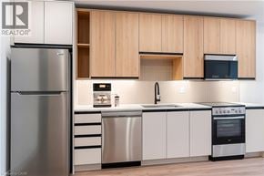 Beamsville condo for rent - A modern kitchen with a stainless steel refrigerator and wooden cabinets.