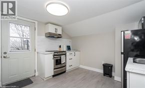 Hamilton apartment for rent - A kitchen with white cabinets and a black refrigerator.