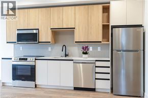 Beamsville condo for rent - A modern kitchen with wooden cabinets and stainless steel appliances.