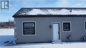 Hamilton multi-family for rent - A house with a white door and windows is surrounded by snow.