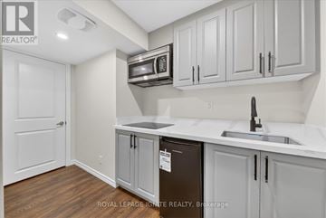 Ajax (Northwest Ajax) apartment for rent - A kitchen with white cabinets and a black fridge.
