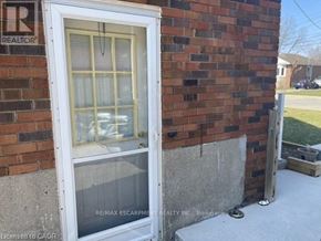 Hamilton (Raleigh) apartment for rent - A window on a brick wall with a sign that says RE/MAX Escarpment REALTY INC. Brokerage.