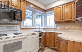 Hamilton (Westcliffe) apartment for rent - A kitchen with wooden cabinets and a white stove top oven.