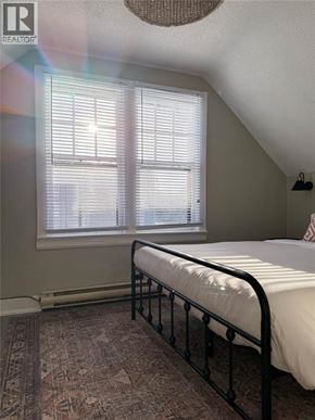 Sarnia apartment for rent - A bedroom with a bed, window, and rug.