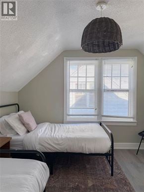 Sarnia apartment for rent - A bedroom with two beds and a hanging light fixture.