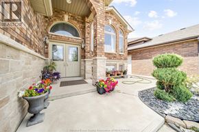 Windsor apartment for rent - A house with a stone wall and a large planter with flowers in front of it.
