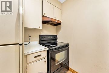 Windsor condo for rent - A black stove top oven in a kitchen with white cabinets.