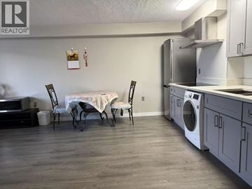 Richmond apartment for rent - A kitchen with a washing machine and a dining table with chairs.