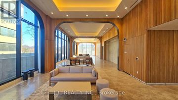 Toronto (Don Valley Village) condo for rent - A spacious living room with a large couch and a view of the outdoors through the windows.