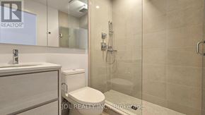 Toronto (Don Valley Village) condo for rent - A bathroom with a glass shower door and a white toilet.