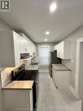 Windsor apartment for rent - A kitchen with white cabinets and a black stove top oven.