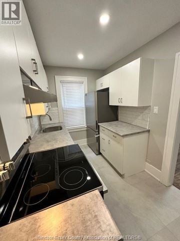 Windsor fourplex for rent - A kitchen with a black stove top oven and white cabinets.