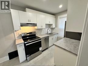 Windsor fourplex for rent - A kitchen with white cabinets and a black stove top oven.