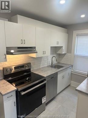 Windsor fourplex for rent - A kitchen with white cabinets and a black stove top oven.