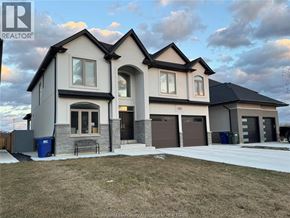 Belle River apartment for rent - A large, modern house with a grey and white exterior and a black roof.