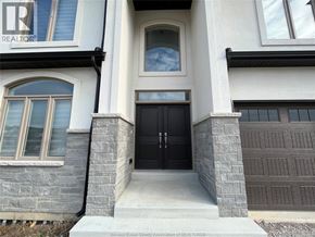 Belle River apartment for rent - A house with a black front door and a window with a view of the sky.