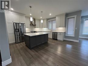 Belle River apartment for rent - A kitchen with wooden floors and a large island in the middle.