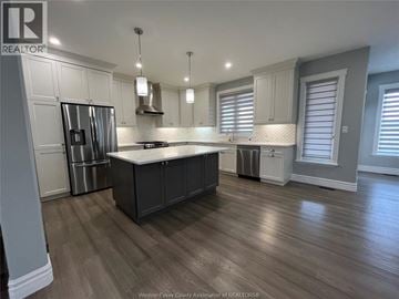 Belle River apartment for rent - A kitchen with wooden floors and a large island in the middle.