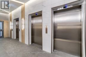 Kitchener condo for rent - A hallway with elevators and a sign that says "Royal LePage Signature Real Estate Brokerage.".