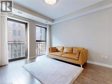 Hamilton condo for rent - A living room with a tan couch and a white rug.
