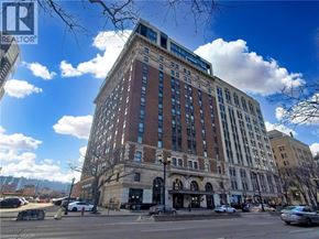 Hamilton condo for rent - A large multi-story building with a blue sky and clouds in the background.
