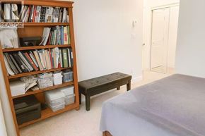 Vancouver apartment for rent - A bedroom with a bed, a bookshelf, and a bench.