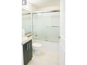 Vancouver apartment for rent - A white toilet sits in a bathroom with a glass shower door.
