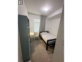 Vancouver apartment for rent - A bedroom with a bed, chair, and a cabinet.