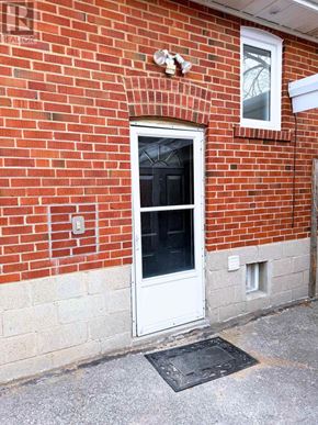 Toronto (Clanton Park) apartment for rent - A red brick house with a white door and a window above it.