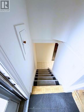 Toronto (Clanton Park) apartment for rent - A stairway with a black carpet leading to a door.