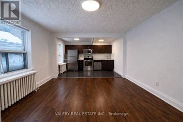 Toronto (Birchcliffe-Cliffside) condo for rent - A room with wood flooring and a kitchenette in the background.
