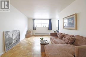 Toronto (Wexford-Maryvale) multi-family for rent - A living room with a brown couch and a painting on the wall.