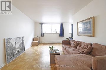 Toronto (Wexford-Maryvale) multi-family for rent - A living room with a brown couch and a painting on the wall.