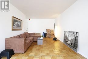 Toronto (Wexford-Maryvale) multi-family for rent - A living room with a brown couch and a painting on the wall.