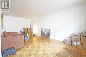 Toronto (Wexford-Maryvale) multi-family for rent - A room with a couch, a chair, and boxes on the floor.