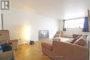 Toronto (Wexford-Maryvale) multi-family for rent - A room with a brown couch, a lamp, and boxes on the floor.
