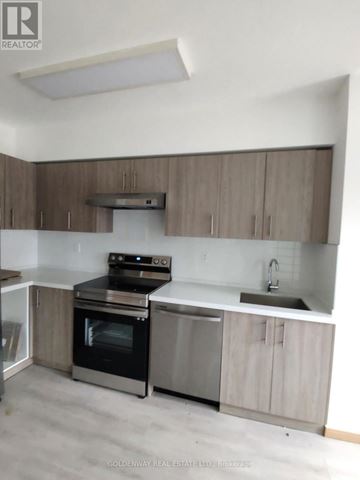 Toronto (L'amoreaux) townhouse for rent - A kitchen with a stove top oven and a microwave.