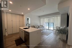 Innisfil condo for rent - A modern kitchen with a large island and a view of the backyard.