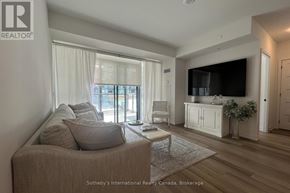 Innisfil condo for rent - A living room with a couch, a chair, a coffee table, and a large window with curtains.