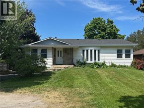 Stoney Creek apartment for rent - A white house with a brown roof and a green lawn in front.
