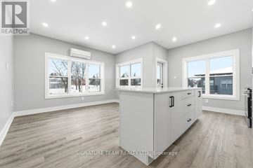 Bonnechere Valley apartment for rent - A spacious, well-lit kitchen and living room with a view of the outdoors through the windows.