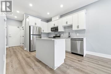 Bonnechere Valley apartment for rent - A modern kitchen with white cabinets and stainless steel appliances.