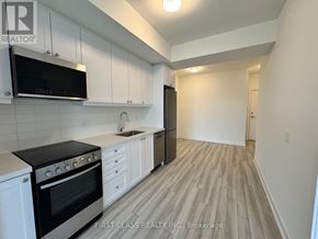 Clarington (Bowmanville) condo for rent - A kitchen with black appliances and white cabinets.