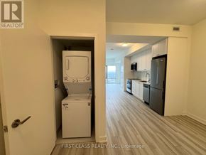 Clarington (Bowmanville) condo for rent - A white washing machine is in a small laundry room.