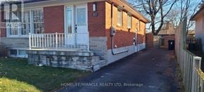 Toronto (Woburn) apartment for rent - A red brick house with a white door and a sign that says "REALTOR".