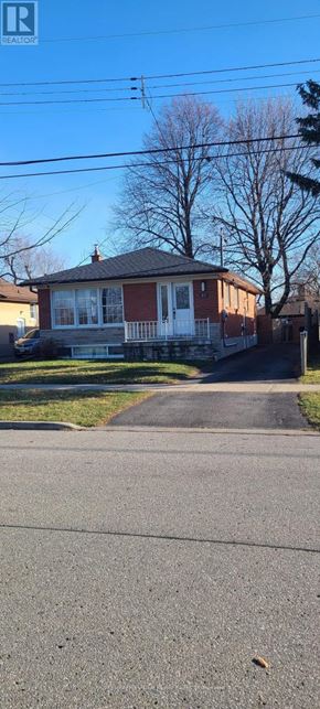 Toronto (Woburn) apartment for rent - A house with a red roof and white windows is situated on a street with a sidewalk.