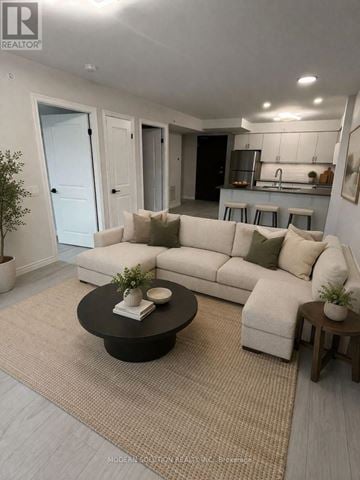 Kitchener condo for rent - A modern living room with a white sofa and a black coffee table.