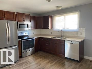 Edmonton apartment for rent - A kitchen with wooden cabinets and stainless steel appliances.