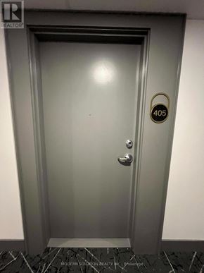 Kitchener condo for rent - A grey door with a gold handle and a sign that says 405.