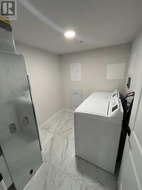 Kitchener condo for rent - A white washing machine in a small laundry room.